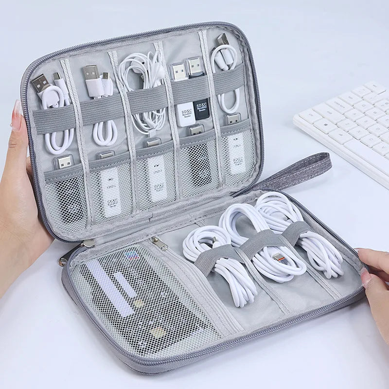 Gray travel organizer with compartments for electronic cables and devices 